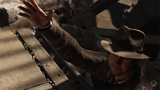 Indiana Jones getting helped up from rail tracks